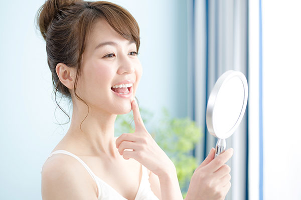 手鏡で歯をチェックする女性